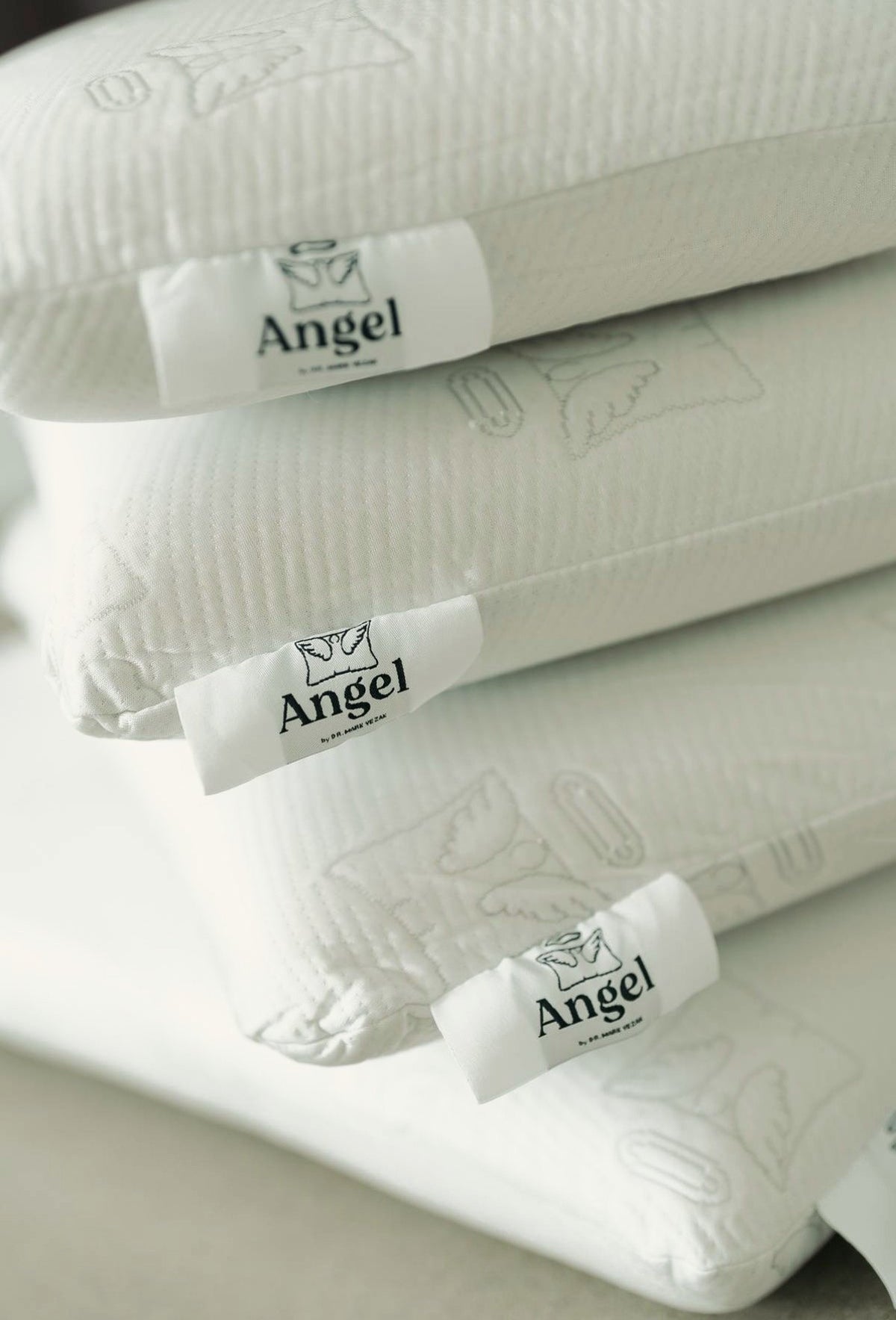 Angel Pillows stacked, showing the embroidered Angel label